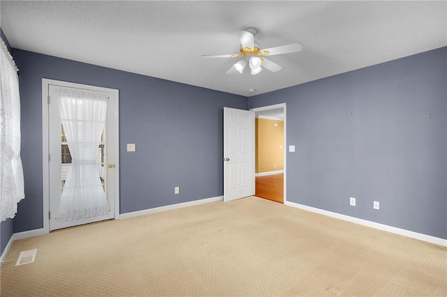 empty room with light colored carpet, baseboards, and visible vents