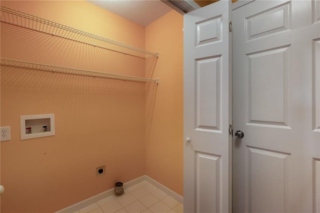 washroom featuring electric dryer hookup, washer hookup, a textured ceiling, light tile patterned floors, and laundry area