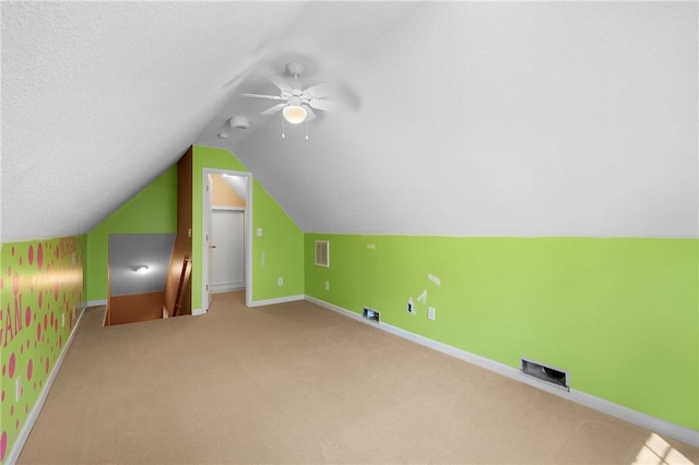 additional living space featuring visible vents, carpet floors, lofted ceiling, and baseboards