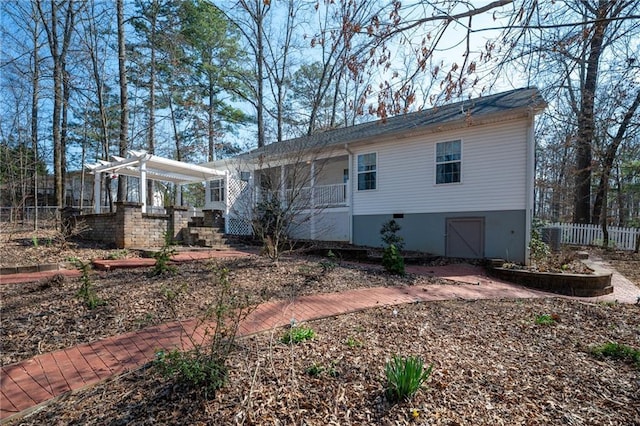 exterior space with an attached garage, a pergola, and fence