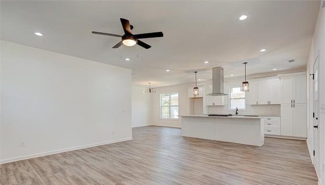 kitchen featuring island exhaust hood, pendant lighting, white cabinetry, and a kitchen island