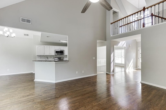 4690 Martins Crossing W Dr, Flowery Branch, GA 30542 - unfurnished living room featuring high vaulted ceiling, ceiling fan, dark wood-style floors, and baseboards