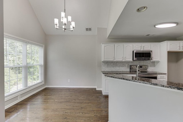 4690 Martins Crossing W Dr, Flowery Branch, GA 30542 - kitchen featuring appliances with stainless steel finishes, lofted ceiling, backsplash, white cabinets, and a chandelier