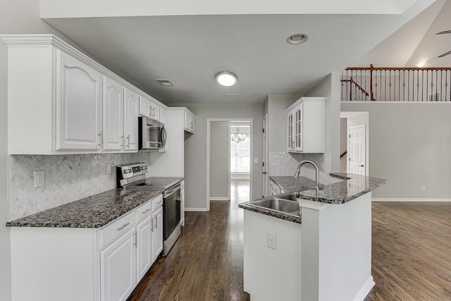 4690 Martins Crossing W Dr, Flowery Branch, GA 30542 - kitchen with stainless steel appliances, dark wood-type flooring, baseboards, a sink, and a peninsula