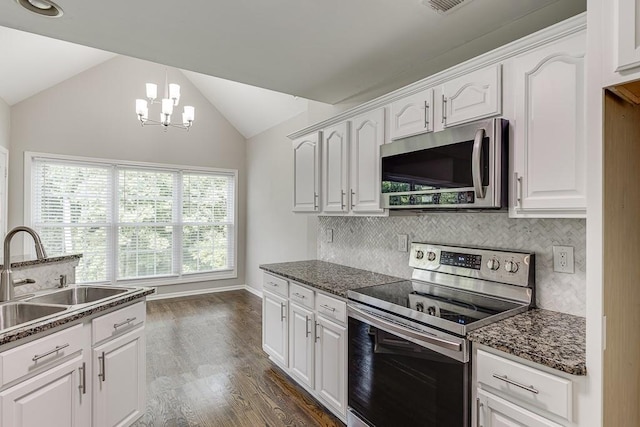4690 Martins Crossing W Dr, Flowery Branch, GA 30542 - kitchen with stainless steel appliances, a sink, vaulted ceiling, white cabinetry, and a chandelier