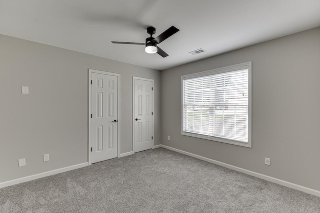 4690 Martins Crossing W Dr, Flowery Branch, GA 30542 - unfurnished bedroom featuring multiple closets, baseboards, carpet flooring, and a ceiling fan