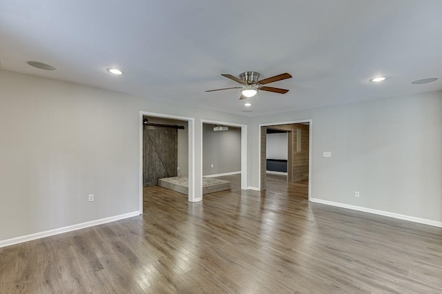 4690 Martins Crossing W Dr, Flowery Branch, GA 30542 - empty room featuring ceiling fan, baseboards, a barn door, wood finished floors, and recessed lighting