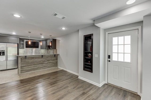 4690 Martins Crossing W Dr, Flowery Branch, GA 30542 - kitchen featuring stainless steel refrigerator with ice dispenser, decorative backsplash, a peninsula, wood finished floors, and recessed lighting