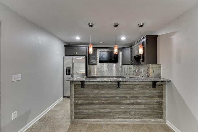 4690 Martins Crossing W Dr, Flowery Branch, GA 30542 - kitchen featuring stainless steel fridge, a peninsula, light stone countertops, decorative backsplash, and a kitchen breakfast bar