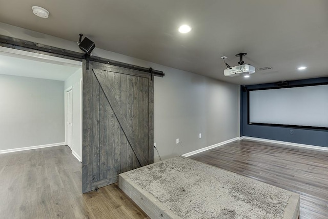4690 Martins Crossing W Dr, Flowery Branch, GA 30542 - home theater room with wood finished floors, a barn door, baseboards, and recessed lighting