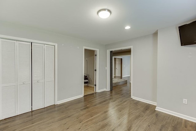 4690 Martins Crossing W Dr, Flowery Branch, GA 30542 - unfurnished bedroom with baseboards, a closet, wood finished floors, and recessed lighting