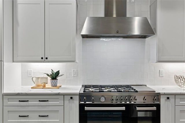 660 Timm Valley Rd NE, Atlanta, GA 30305 - kitchen featuring light stone countertops, gas range, wall chimney exhaust hood, and backsplash