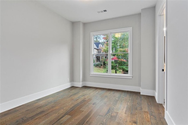 unfurnished room with dark hardwood / wood-style flooring