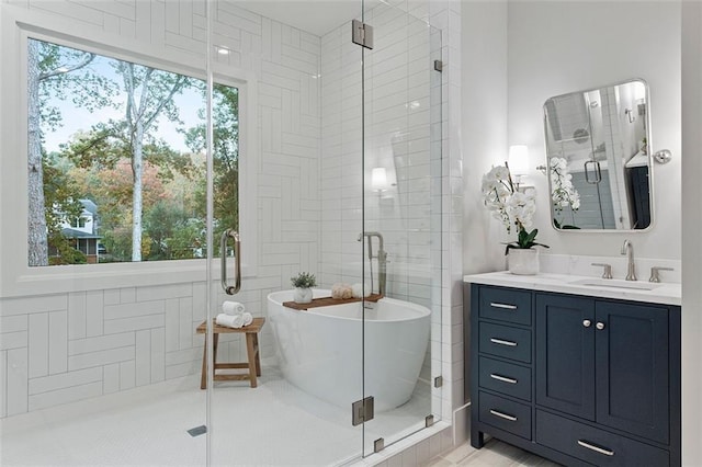 bathroom with independent shower and bath, vanity, and plenty of natural light