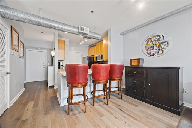 800 Peachtree St NE Unit 1504, Atlanta, GA 30308 - kitchen with freestanding refrigerator, stainless steel microwave, light wood-style floors, light countertops, and baseboards