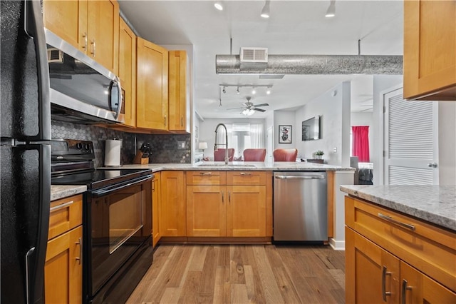 800 Peachtree St NE Unit 1504, Atlanta, GA 30308 - kitchen with black appliances, a sink, track lighting, light wood-style floors, and a peninsula