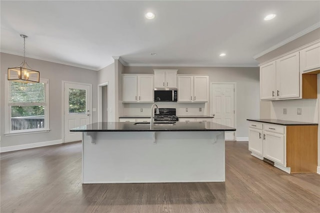 420 Gold Xing, Canton, GA 30114 - kitchen with stainless steel microwave, dark countertops, white cabinetry, dark wood finished floors, and crown molding