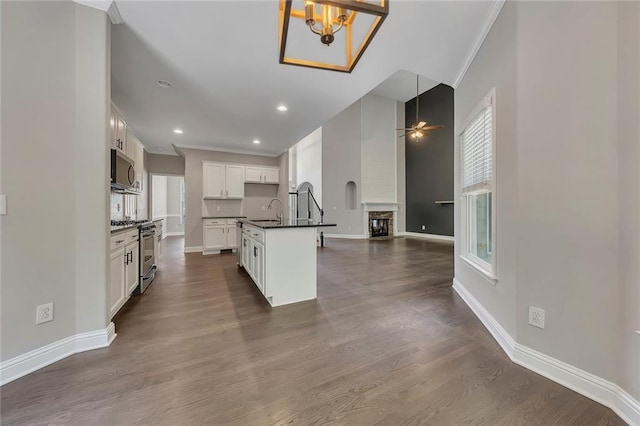 420 Gold Xing, Canton, GA 30114 - kitchen with appliances with stainless steel finishes, dark countertops, ornamental molding, ceiling fan, and open floor plan