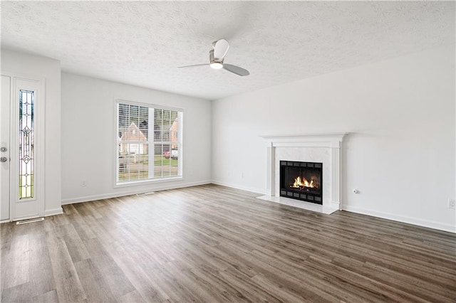 unfurnished living room featuring wood-type flooring, ceiling fan, and a textured ceiling