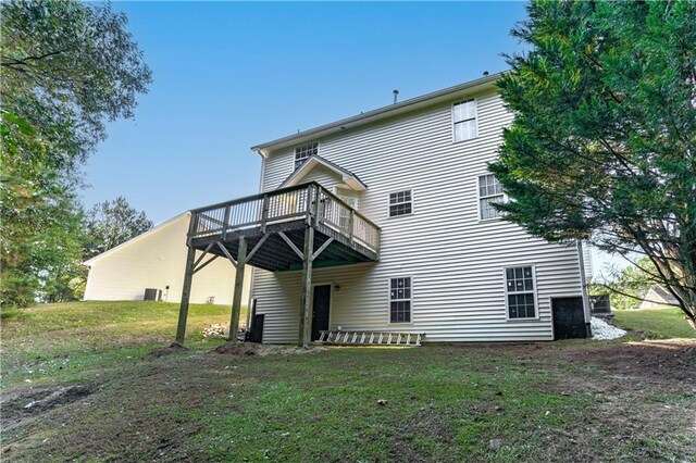 rear view of property featuring a deck and a yard