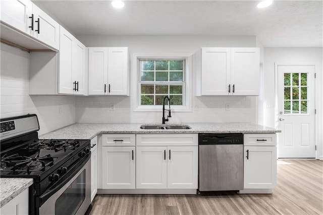 kitchen featuring a wealth of natural light, stainless steel appliances, and white cabinetry