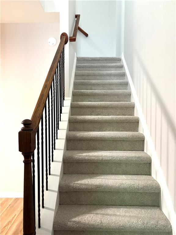 stairway featuring baseboards and wood finished floors