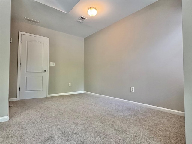 spare room with visible vents, carpet, and baseboards