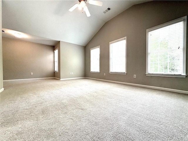 unfurnished room with lofted ceiling, carpet flooring, visible vents, ceiling fan, and baseboards