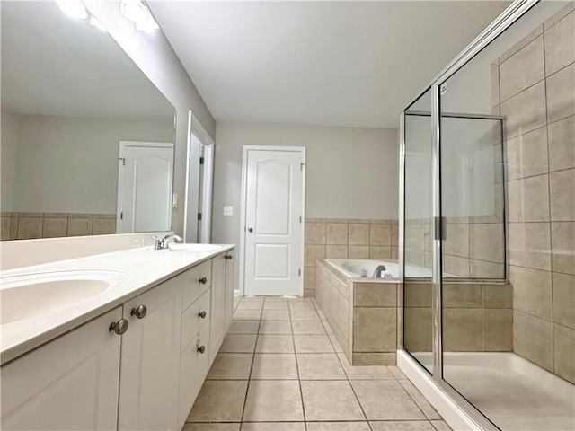bathroom featuring a sink, a bath, a stall shower, double vanity, and tile patterned flooring
