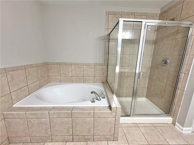 bathroom featuring a garden tub, a shower stall, and tile patterned flooring