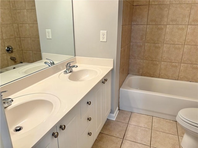 bathroom with toilet, tile patterned flooring, and a sink