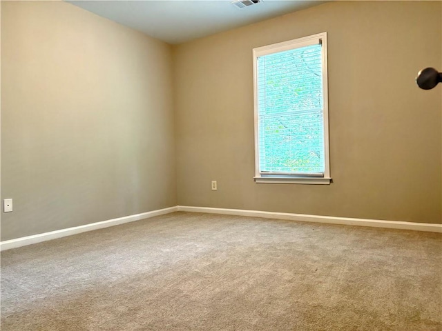 carpeted spare room with visible vents and baseboards