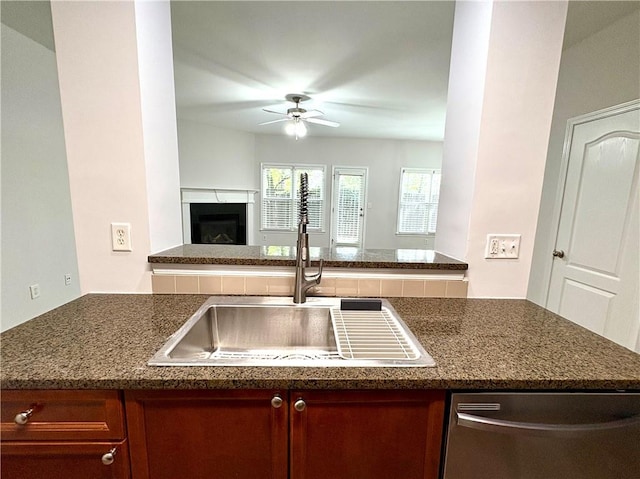 kitchen with a sink, a fireplace, ceiling fan, dishwasher, and open floor plan