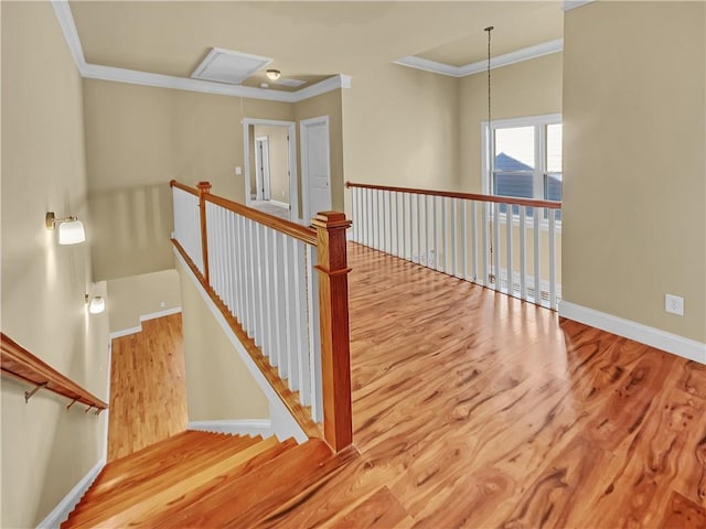 stairs with crown molding, baseboards, and wood finished floors