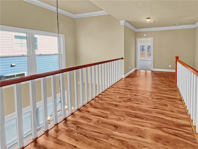 hallway featuring crown molding, wood finished floors, and baseboards