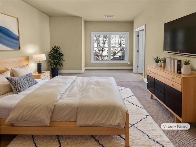 bedroom featuring visible vents, light colored carpet, and baseboards