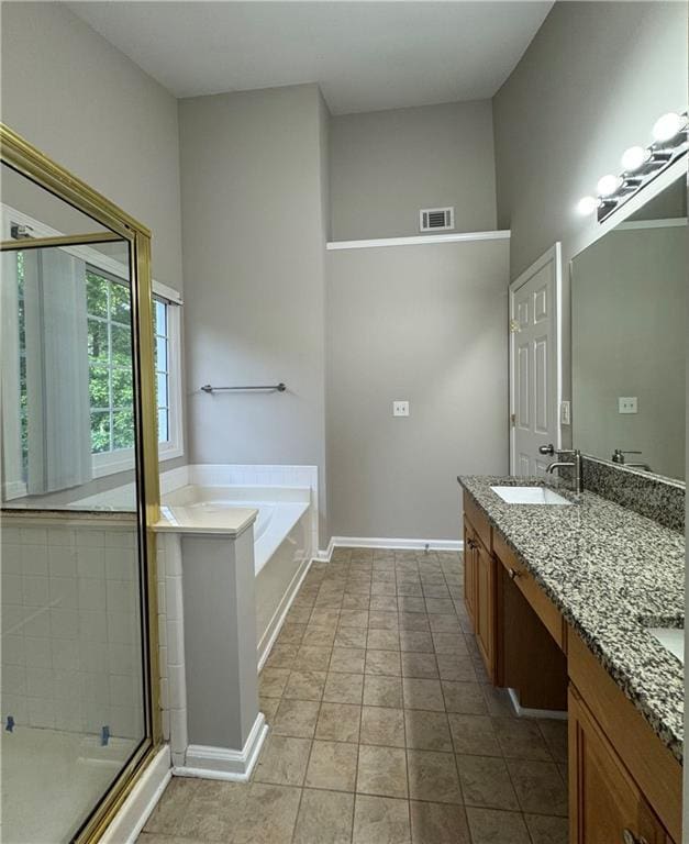 1415 Stoney Field Pl, Lawrenceville, GA 30043 - bathroom featuring double vanity, a garden tub, a stall shower, and baseboards
