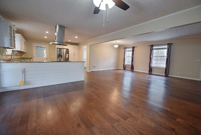 unfurnished living room with ceiling fan, dark hardwood / wood-style flooring, a textured ceiling, and ornamental molding