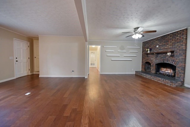 unfurnished living room with ceiling fan, dark hardwood / wood-style floors, a textured ceiling, and a brick fireplace