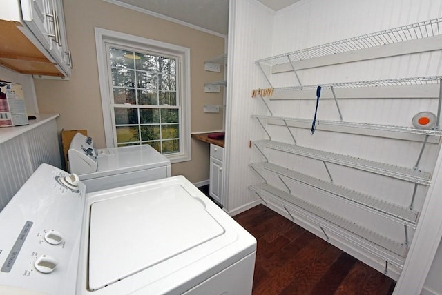 washroom with cabinets, dark hardwood / wood-style flooring, washer and clothes dryer, and ornamental molding