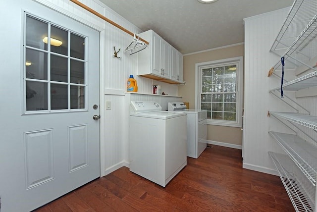 laundry area with dark hardwood / wood-style floors, cabinets, crown molding, and washing machine and clothes dryer