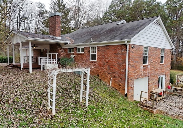 rear view of property featuring ceiling fan and a deck