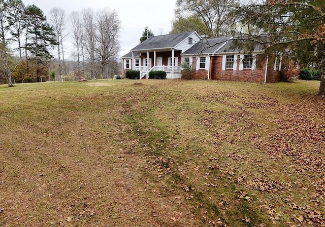 ranch-style house with a front yard and a porch