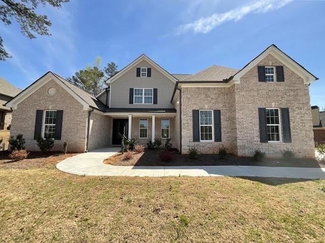 view of front of property with a front lawn and brick siding