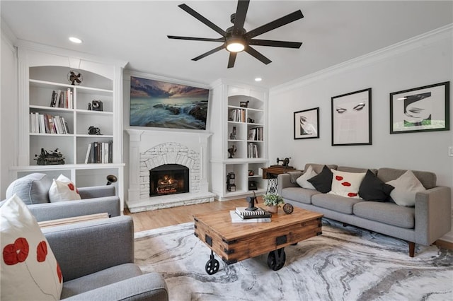 4030 Scenic View Ct, Cumming, GA 30028 - living area with built in shelves, crown molding, a ceiling fan, a stone fireplace, and wood finished floors
