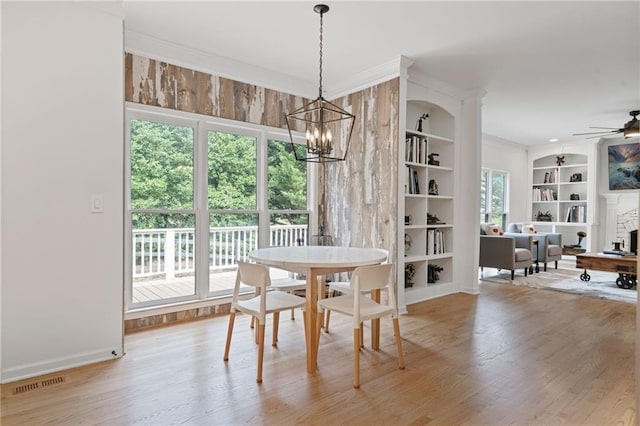 4030 Scenic View Ct, Cumming, GA 30028 - dining room with crown molding, built in shelves, visible vents, wood finished floors, and ceiling fan with notable chandelier