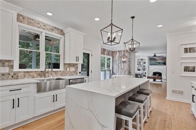 4030 Scenic View Ct, Cumming, GA 30028 - kitchen with a sink, visible vents, a center island, ornamental molding, and ceiling fan with notable chandelier