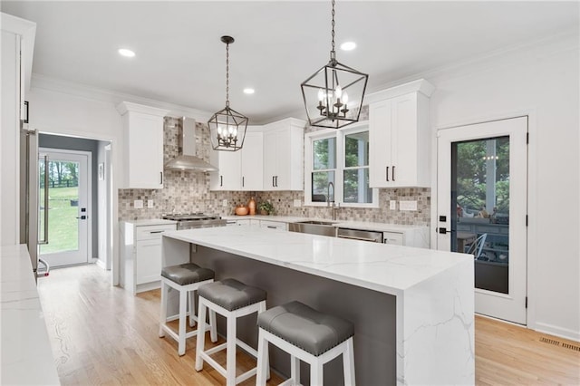 4030 Scenic View Ct, Cumming, GA 30028 - kitchen with plenty of natural light, a sink, a notable chandelier, wall chimney exhaust hood, and crown molding