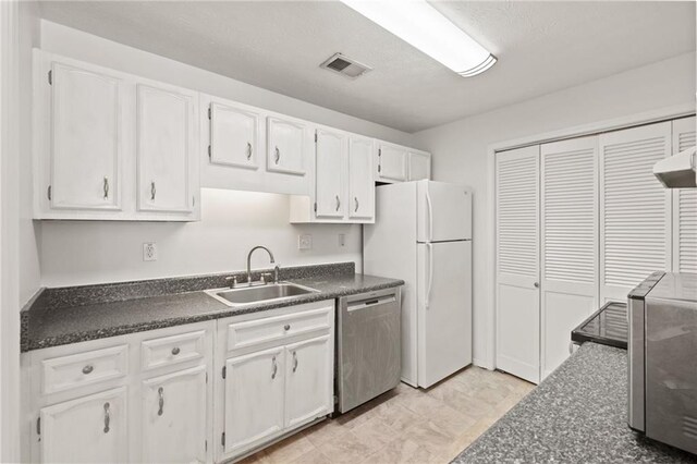 kitchen with appliances with stainless steel finishes, sink, and white cabinets