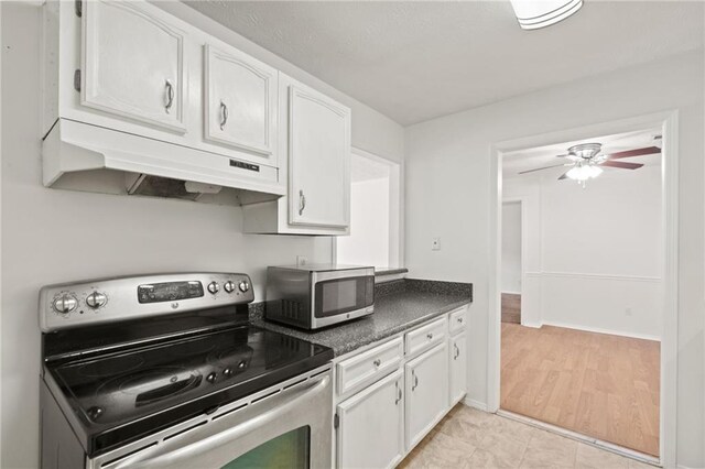 kitchen featuring white cabinetry, appliances with stainless steel finishes, light tile patterned floors, and ceiling fan